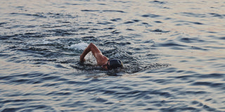 Open-water swimmer doing front crawl at dusk