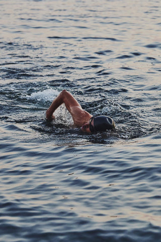 Open-water swimmer doing front crawl at dusk
